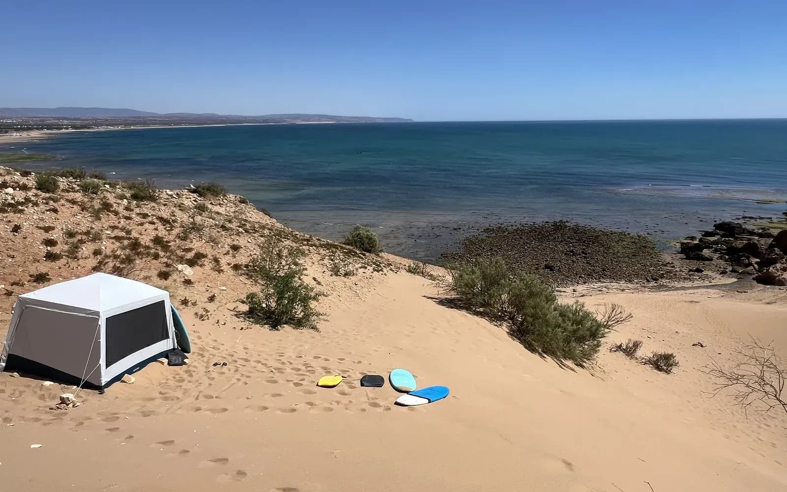 The Ouassane dunes facing the Atlantic, sandboards laid out on the sand at the foot of the slope