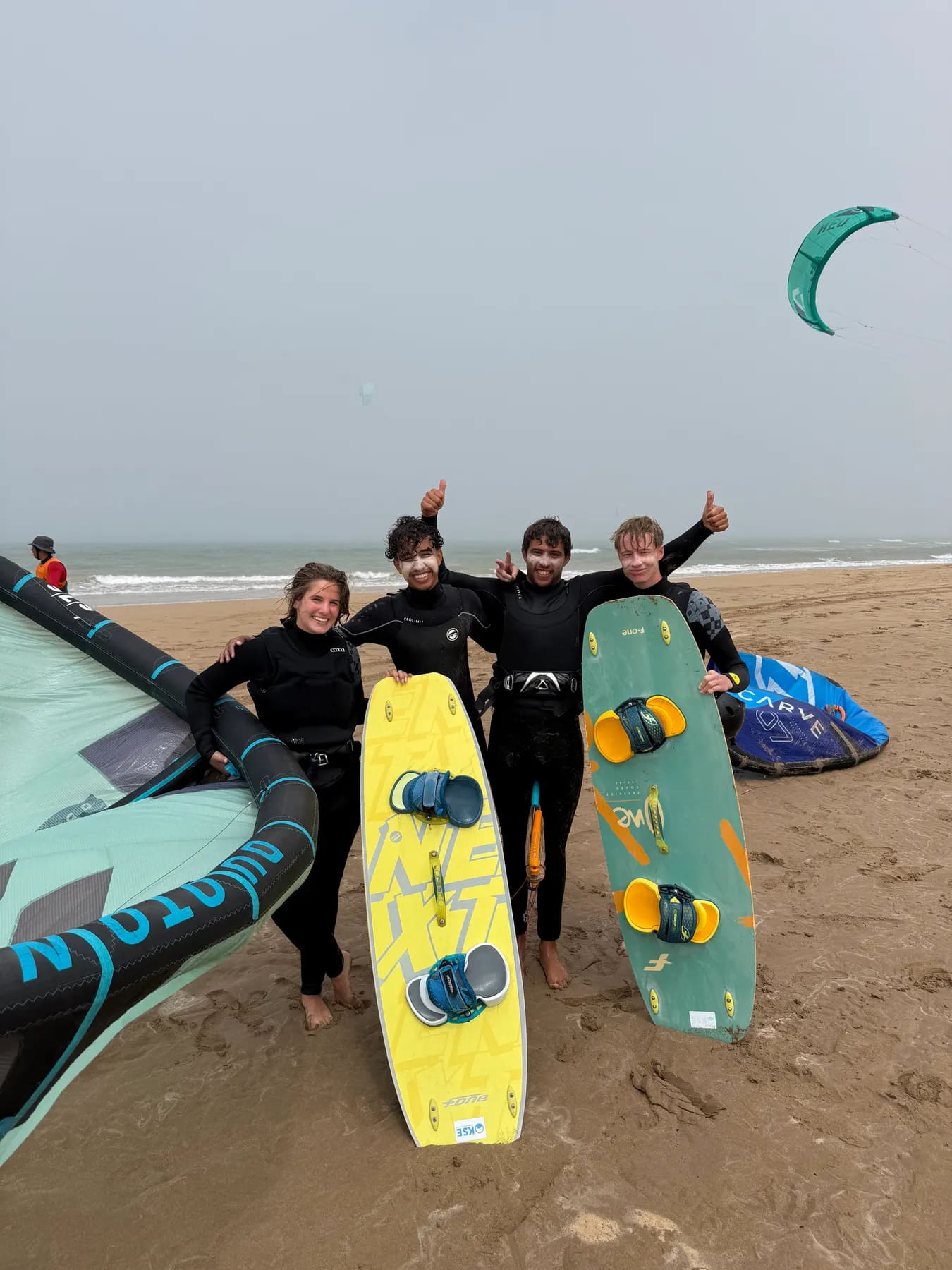 École de kitesurf à Essaouira — élèves et moniteurs réunis sur la plage de Diabat avec leurs planches twin-tip et leurs ailes, Windy Essaouira