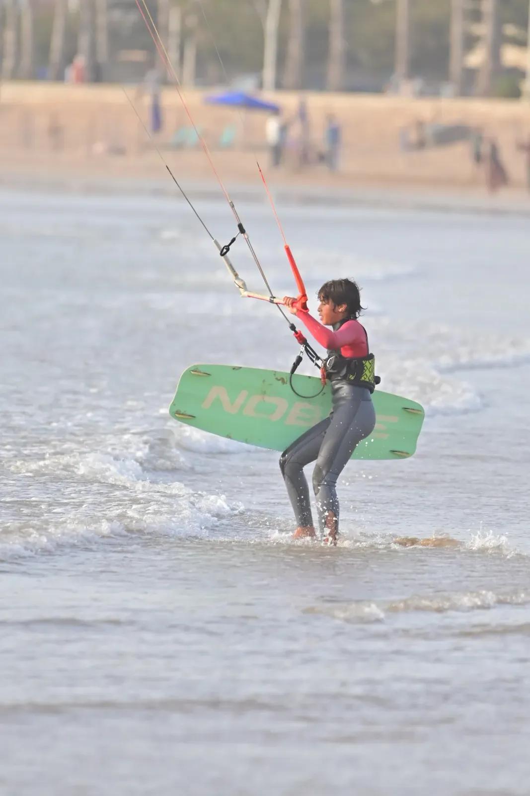Young kitesurf student in Essaouira carrying the board through the shorebreak — Windy Essaouira school